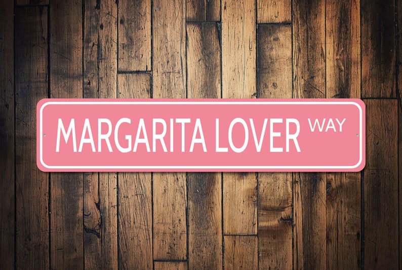 May include: Pink metal sign with white text that reads "Margarita Lover Way".