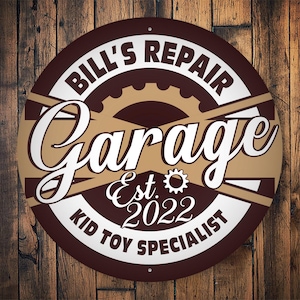 Pode incluir: Uma placa redonda marrom e branca com o texto "Bill's Repair Garage Est. 2022 Kid Toy Specialist" em letras brancas. A placa tem um design de engrenagem marrom no centro.