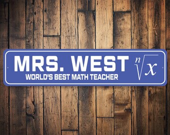 Puede incluir: Un letrero azul y blanco con el texto "Mrs. West World's Best Math Teacher" y un símbolo radical matemático blanco con la letra "x" dentro.