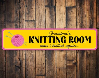 May include: A yellow and pink sign with the text "Grandma's Knitting Room oops i knitted again..." and a pink ball of yarn with two knitting needles.