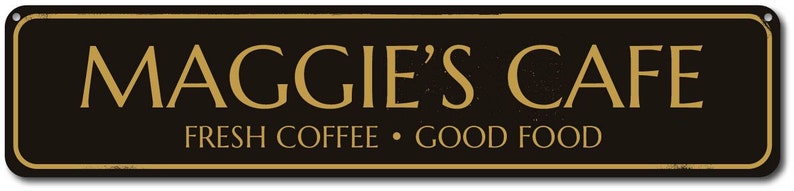 Pu&ograve; includere: Segno nero e dorato con il testo "Maggie's Cafe" e lo slogan "Fresh Coffee - Good Food".