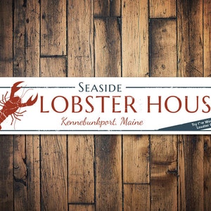 May include: White metal sign with red lobster illustration and the text "SEASIDE LOBSTER HOUSE Kennebunkport, Maine Try our World Famous Lobster Chowder!"