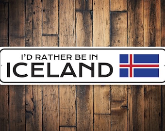 May include: White metal sign with the text "I'd rather be in Iceland" and the Icelandic flag in the upper right corner.