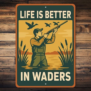 May include: Rectangular metal sign with a vintage illustration of a hunter in waders aiming a shotgun at flying ducks. The sign has the text "LIFE IS BETTER IN WADERS" in white letters.
