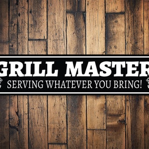 May include: Black and white metal sign with the text "Grill Master Serving Whatever You Bring!" with a grill graphic on each side.