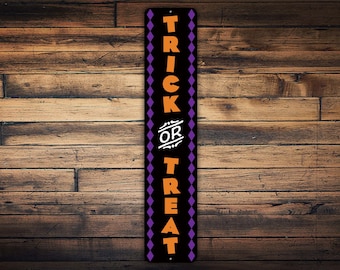 May include: Black metal sign with a purple and orange diamond pattern. The sign says "Trick or Treat" in orange letters.
