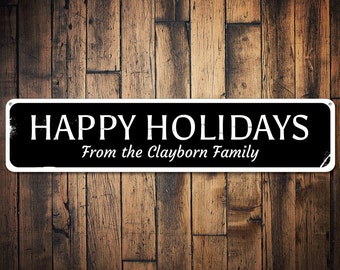 May include: Black and white sign with the text "HAPPY HOLIDAYS From the Clayborn Family" on a wood background.