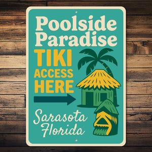 May include: A teal metal sign with the words "Poolside Paradise" and "Tiki Access Here" in white and yellow. The sign features a palm tree, a tiki hut, and the words "Sarasota Florida".