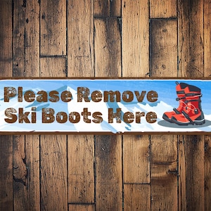 May include: A blue and white sign with the text "Please Remove Ski Boots Here" and a cartoon image of a red ski boot with black buckles.