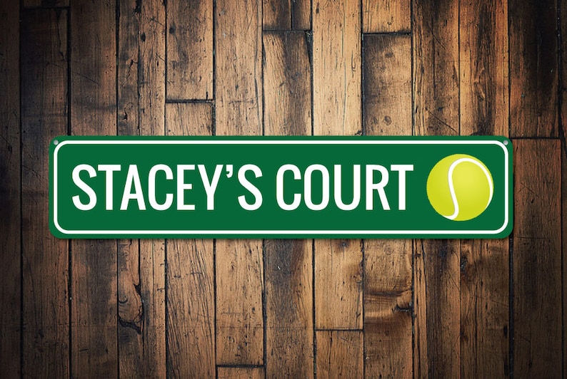 K&ouml;nnte beinhalten: Gr&uuml;nes Metallschild mit wei&szlig;em Text "Stacey's Court" und einer gelben Tennisballgrafik.
