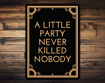 May include: Black and gold metal sign with an art deco design. The sign reads "A little party never killed nobody."