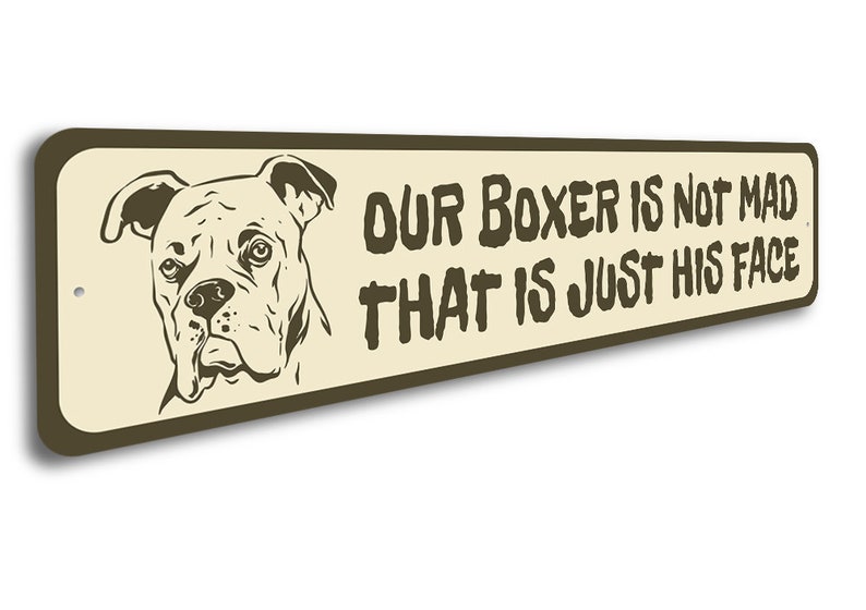 Puede incluir: Un letrero de metal beige con texto marr&oacute;n y una ilustraci&oacute;n marr&oacute;n de un perro boxer. El texto dice "Nuestro Boxer no est&aacute; enojado, esa es solo su cara."