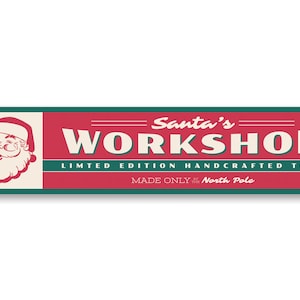 May include: A red and green sign with the text "Santa's Workshop" in white. The sign also says "Limited Edition Handcrafted Toys" and "Made Only at the North Pole". A cartoon image of Santa Claus is in the upper left corner of the sign.