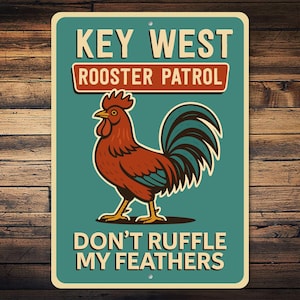 May include: A rectangular metal sign with a teal background and a rooster illustration. The sign reads "KEY WEST ROOSTER PATROL" above the rooster and "DON'T RUFFLE MY FEATHERS" below. The rooster is brown, teal, and yellow.