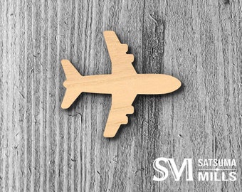 May include: A wooden cutout of an airplane in the shape of a silhouette. The airplane is light brown and is on a gray wood background.