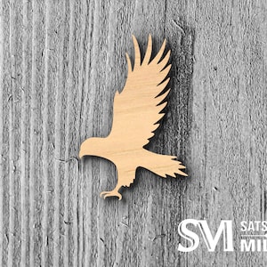 May include: Wooden cutout of an eagle in flight, with wings spread wide. The eagle is facing left, with its head turned to the right. The cutout is on a woodgrain background with the text "SATSUMA MILLS" in white letters.
