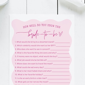 May include: A pink and white bridal shower game card titled "How Well Do You Know The Bride-to-Be?" with fill-in-the-blank questions. The card features a decorative pink shape at the top and a logo in the upper right corner.