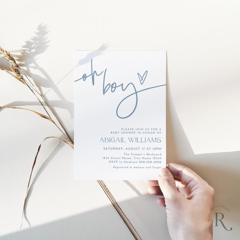 May include: A white baby shower invitation with blue text. The words "oh boy" are written in a cursive font, with a heart symbol. The invitation includes details for Abigail Williams' baby shower, including the date, time, and location.