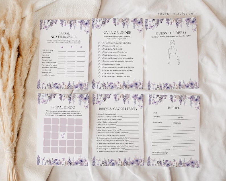 Op de afbeelding: Een set met printbare bruiloftsspelletjes met een bloemenmotief. De spellen omvatten Bridal Scattergories, Over or Under, Guess the Dress, Bridal Bingo, Bride & Groom Trivia en een blanco receptenkaart.