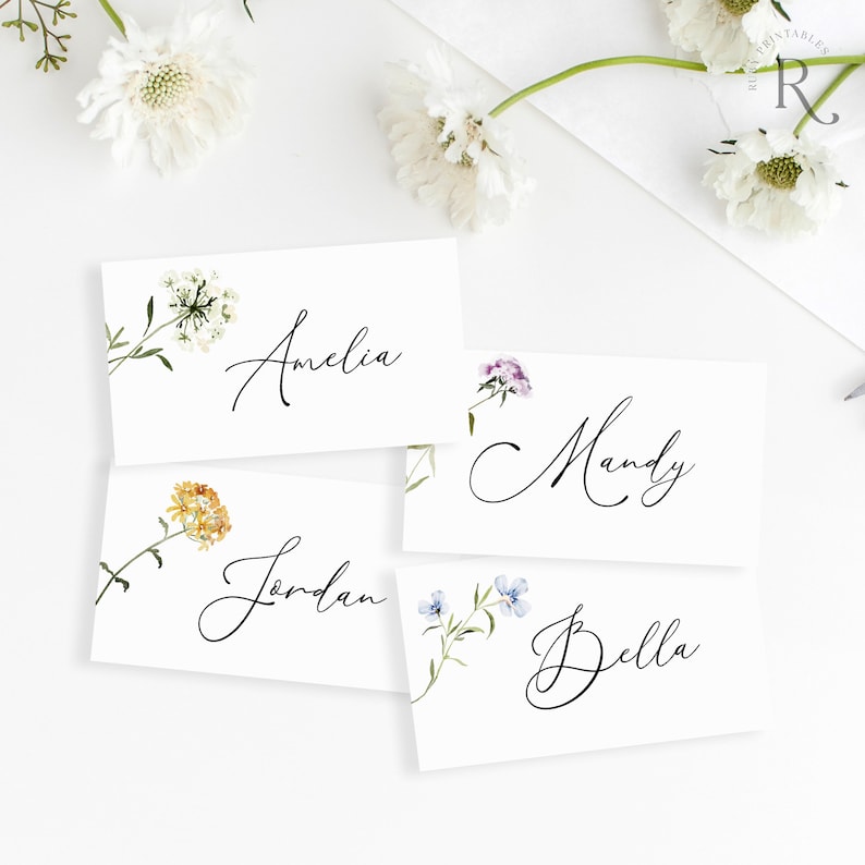 Peut inclure: Quatre cartes de place blanches avec des illustrations florales et des noms &eacute;crits &agrave; la main&nbsp;: Amelia, Jordan, Mandy et Bella.