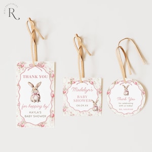 May include: Three baby shower gift tags with floral and bunny designs. The tags are rectangular, square, and circular, with text that reads "Thank You" and "Baby Shower." Each tag has a light brown ribbon for hanging.