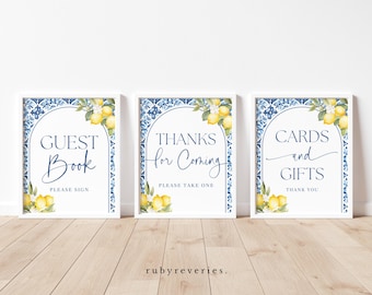 May include: Three framed signs with white borders. Each sign features a blue and white tile design, lemon and floral accents, and text that reads "Guest Book," "Thanks for Coming," and "Cards and Gifts."