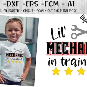May include: A white t-shirt with a black and red graphic that says "Lil' Mechanic in training" with a wrench and screwdriver design. There are five yellow stars below the text. A young boy is wearing the shirt.