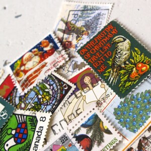 May include: A collection of vintage Christmas stamps featuring a variety of designs, including a bird on a branch, a Christmas tree, and a Santa Claus. The stamps are in various colors, including red, green, blue, and white. The text on the stamps reads "On the first day of Christmas my true love sent to me..." and "Canada 15".