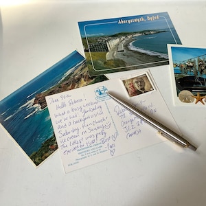 Je t'écris une carte postale ! Vous recevrez une note manuscrite sur une carte postale vintage intéressante et aux couleurs vives, avec votre nom et votre date