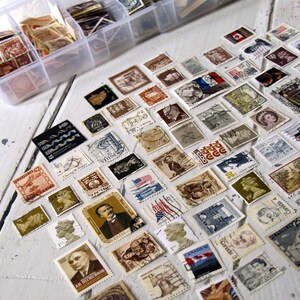 May include: A collection of vintage postage stamps from around the world, featuring a variety of designs and colours. The stamps are arranged in a grid pattern on a white surface. Some of the stamps feature images of people, animals, and landmarks.
