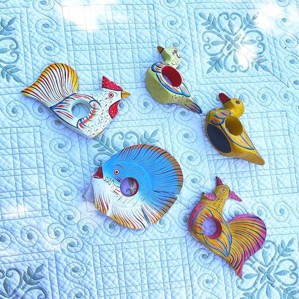 Puede incluir: Cinco anillos de servilleta de madera pintados a mano con forma de pájaros y un gallo. Los anillos están pintados en colores brillantes, incluyendo azul, amarillo, rojo y verde. Los anillos son una forma divertida y festiva de añadir un toque de fantasía a tu mesa.