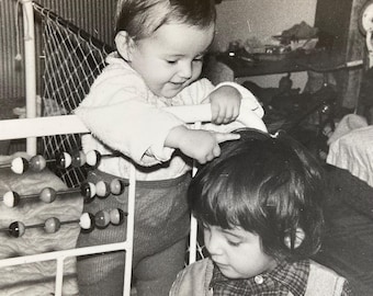 Old photo pair of cute baby in playpen crib little girl playing brother sister adorable candid family friends kids black white photograph