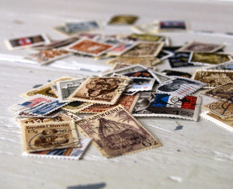 May include: A collection of vintage postage stamps from around the world, featuring various designs and colours. Some stamps include text such as "Republik Osterreich" and "Papua New Guinea".