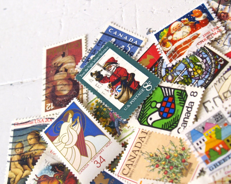 May include: A collection of vintage Christmas stamps featuring various designs, including a Santa Claus, a dove, a Christmas tree, and a stained glass window. The stamps are from Canada and the United States, and some feature the text "Twas the Night Before Christmas" and "Canada Christmas Noel".
