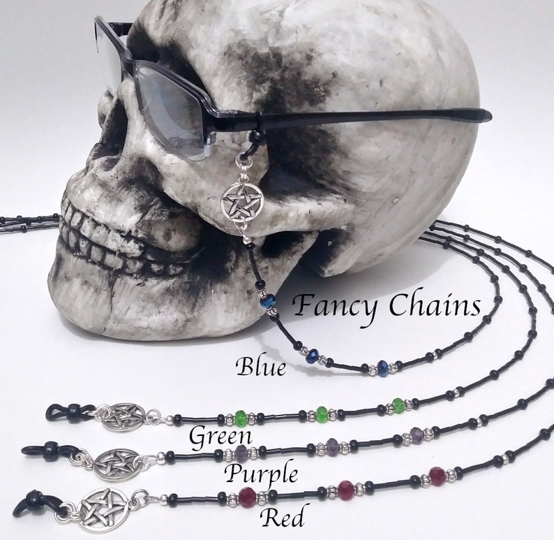 May include: Black eyeglass chains with a silver pentagram charm and colorful beads. The image shows chains in blue, green, purple, and red. The text "Fancy Chains" is visible.