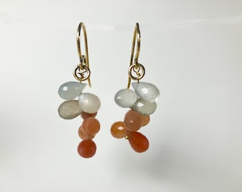 Goldene Ohrringe mit orangefarbenen Mondsteinquasten