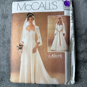 Puede incluir: Patrón de costura McCall's para un vestido de novia. El patrón presenta un vestido blanco largo con escote cuadrado y mangas largas. El paquete incluye imágenes del vestido terminado y el logotipo "Alicyn Exclusives".