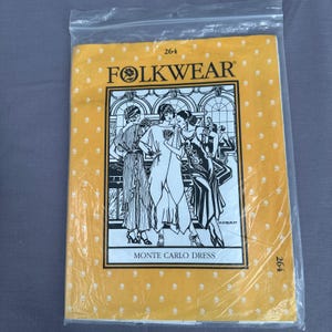 Puede incluir: Un patrón de costura Folkwear para el vestido Monte Carlo, con una cubierta amarilla e ilustraciones de mujeres con vestidos de flapper. El paquete está sellado en una bolsa de plástico transparente. El texto "FOLKWEAR" y "MONTE CARLO DRESS" son visibles.
