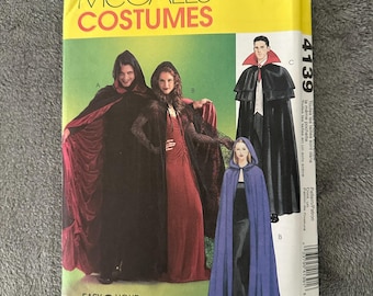 May include: A McCall's Costumes pattern envelope featuring illustrations of hooded capes and cloaks. The cover displays images of costumes in black, red, and blue. The text reads "Easy 2 Hour" and "Costumes".