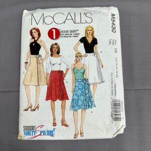 May include: A McCall's M5430 sewing pattern envelope featuring illustrations of three skirt styles. The text includes 1 HOUR SKIRT, Suddenly You're Sewing, and size range D5 (12-14-16-18-20). The illustrations show a tan skirt, a red skirt, and a blue floral skirt.