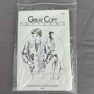 May include: A sewing pattern titled "Great Copy Patterns" in a clear plastic bag. The pattern features illustrations of a cardigan with sewing appliqués. The text "Cardigan with Sewing Appliques" and the number "#865" are visible.