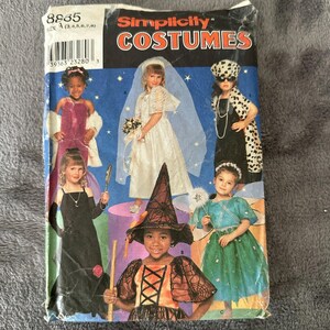 May include: Simplicity Costumes pattern envelope featuring children in various costumes. The costumes include a bride, witch, and other formal dresses. The envelope is blue with the word "COSTUMES" in orange and white.