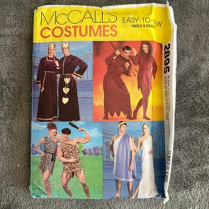 May include: A sewing pattern for four different costumes. The costumes include a king and queen, a devil and a witch, a caveman and a cavewoman, and a Greek god and goddess. The pattern is from McCall's and is labelled "Easy-to-Sew".