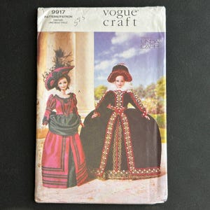 May include: Vogue Craft sewing pattern number 9917 for a doll. The pattern is for two different outfits: a red and black dress with a hat and a black dress with gold trim. The pattern is designed by Linda Carr.