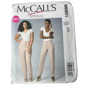 May include: McCall's M6901 sewing pattern. The pattern features two models wearing a white top and light pink pants. The pattern is labeled "Easy" and includes the text "Fashion That Fits". The size is OSZ.