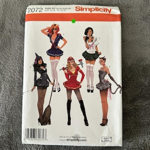 May include: A Simplicity sewing pattern envelope 2072 featuring illustrations of five different costume designs including a witch, a sailor, a firefighter, a schoolgirl, and a cat. The white paper envelope displays the brand name and size range R5.
