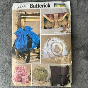 May include: A Butterick 3485 sewing pattern envelope featuring illustrations of various bags including a blue satin drawstring pouch with black tassels, a rectangular patterned clutch, a white drawstring bag with gold embroidery, a pink floral pouch, a green drawstring bag, and a brown shoulder bag.