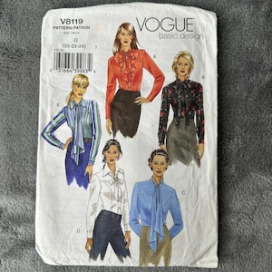 Puede incluir: Patrón de costura Vogue basic design V8119. El patrón presenta ilustraciones de blusas con varios estilos, incluyendo una blusa roja con volantes, una blusa negra floral, una blusa a rayas, una blusa blanca y una blusa azul.
