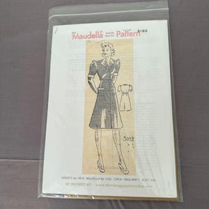 May include: A vintage sewing pattern by Maudella, pattern number 3182, featuring a 1940s dress design. The illustration shows a woman in a double-breasted dress with pockets. The bust size is 32 inches. The pattern is in a clear plastic sleeve.