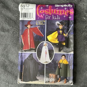 May include: Simplicity pattern 5512 for kids' costumes. The pattern includes four costumes: a wizard, a knight, a hooded cloak, and a forest ranger. The pattern is for sizes 3-8.